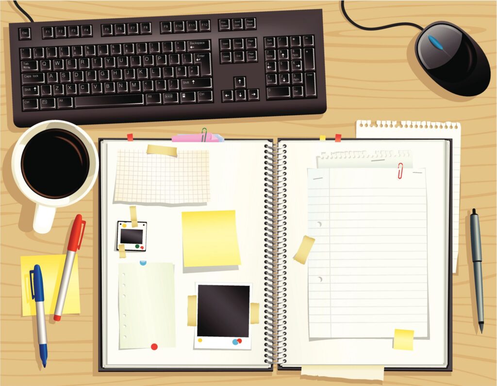 Wooden office desktop with scrapbook and keyboard